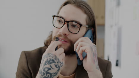 man talking on phone and applying lipstick
