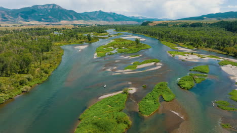 aerial view of a scenic river winding through a green valley with mountains