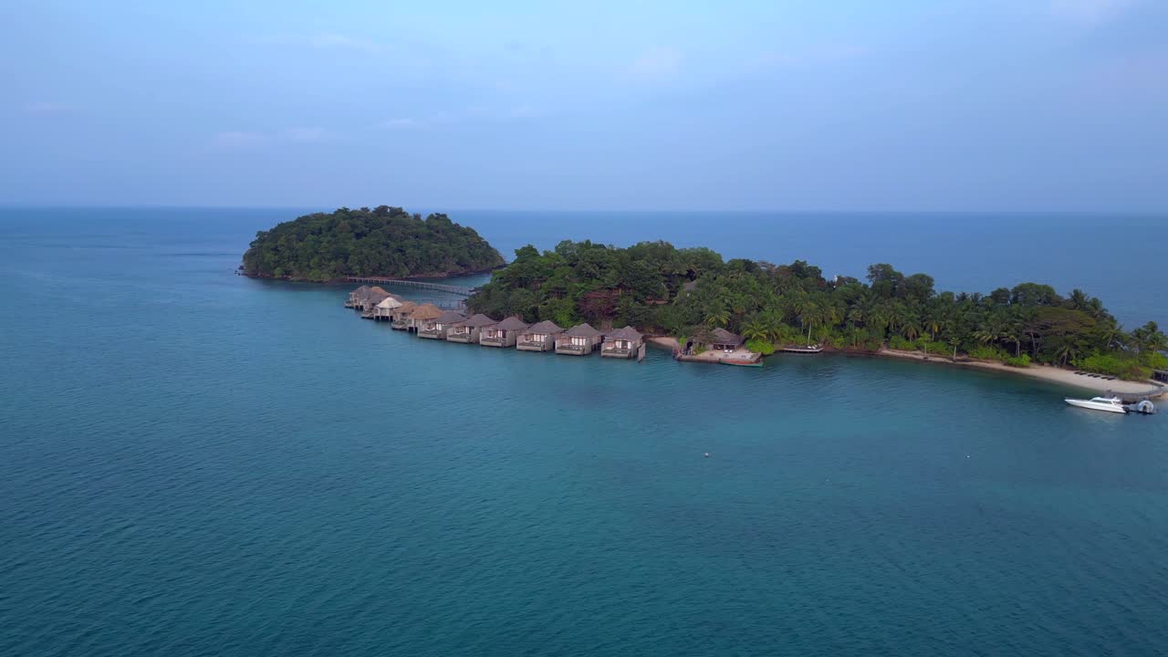 Song Saa Private Island, luksusowy kurort łączący dwie wyspy pomostem i bungalowami na wodzie. Niesamowity widok z lotu ptaka, szeroki obrót drona.