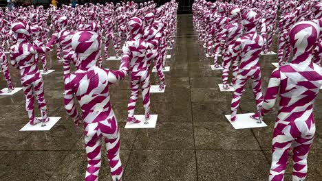 close up shot of plastered pink and white kid dolls on square in cologne, germany - number of raped kids, artwork - shattered souls in a sea of silence