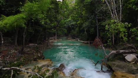 aerial: dolly shot over waterfalls cascading through tropical jungle rainforest