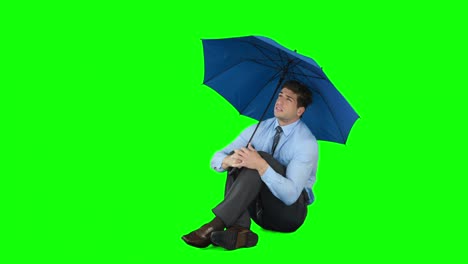 young businessman sheltering with umbrella