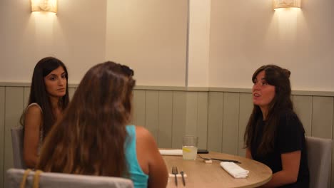 Tres-Mujeres-Manteniendo-Una-Conversación-Seria-En-Una-Habitación-Bien-Iluminada-Antes-De-Cenar.