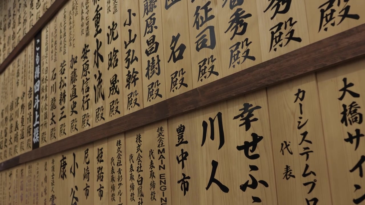 Plaques votives en bois avec calligraphie japonaise noire des noms des donateurs dans un temple au Japon