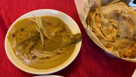 assortment of mutton nihari, naan and omar khayam ka murgh dish.
