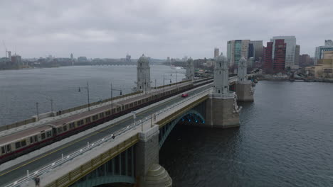 Verfolgung-Des-U-Bahn-Zugs-Der-Roten-Linie,-Der-An-Bewölkten-Tagen-Auf-Der-Longfellow-Brücke-über-Den-Breiten-Charles-River-Fährt.-Boston,-USA