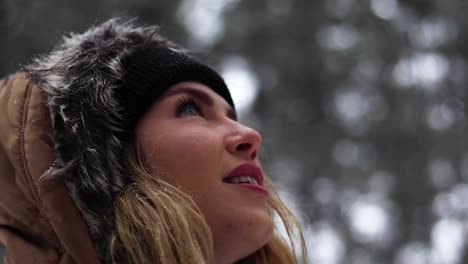 tight shot of a beautiful blonde women in awe looking at her surroundings in a pine forest in canada