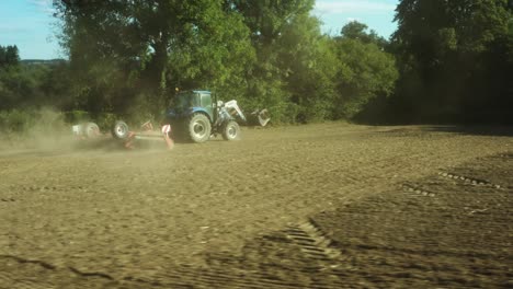 Toma-Aérea-Cinematográfica-De-Un-Tractor-En-El-Paisaje-De-Francia,-árboles,-Carreteras-Y-Pueblos.