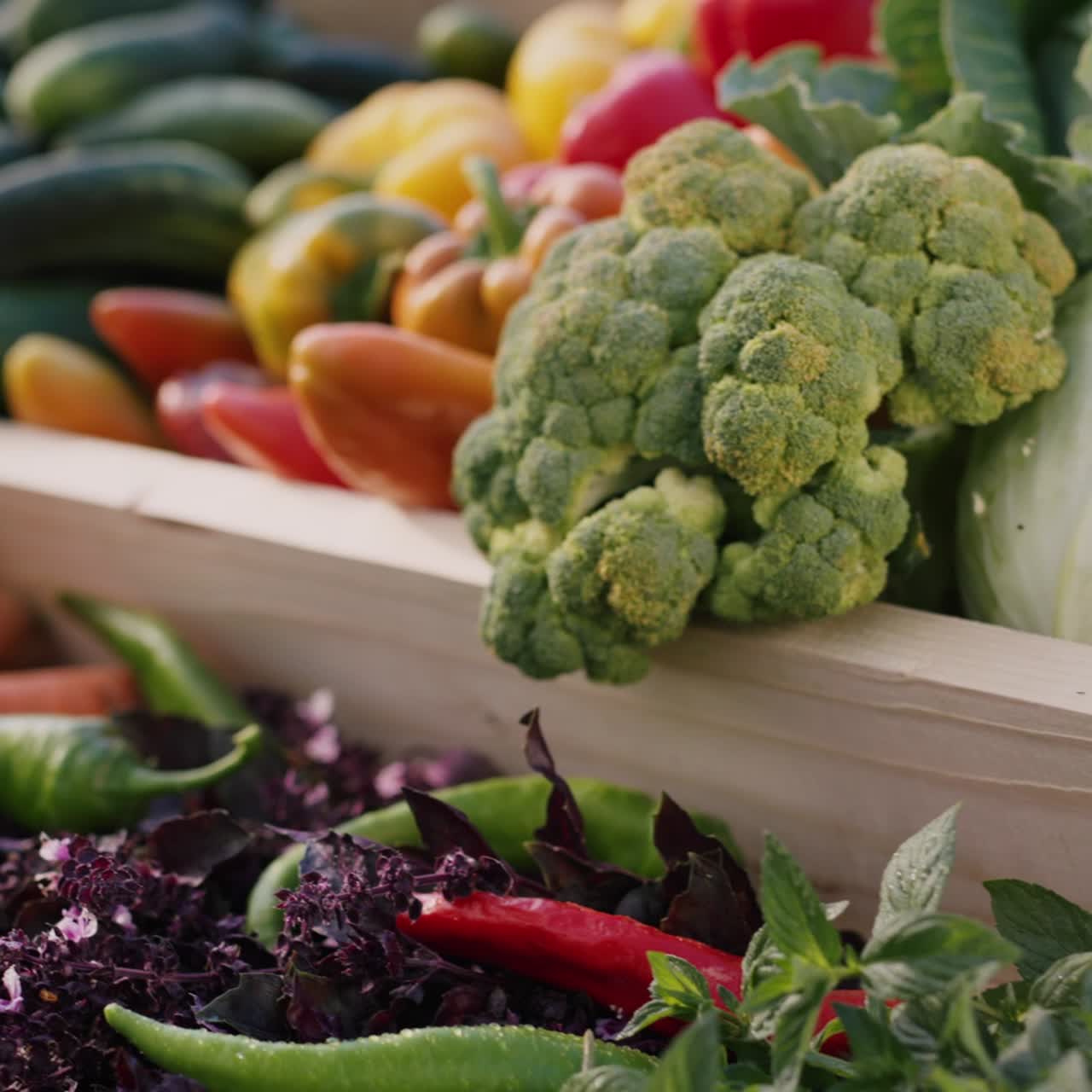 un mostrador de madera con verduras en el mercado de agricultores
