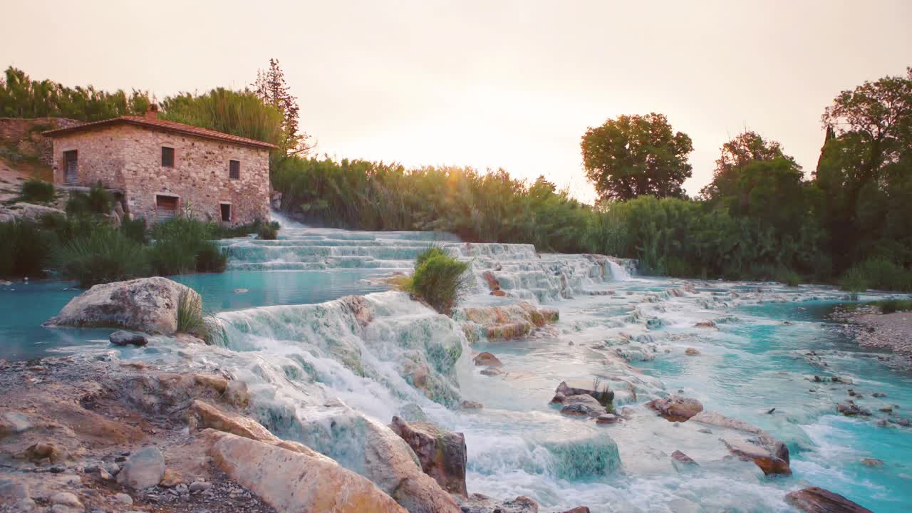 Saturnia hot springs at sunrise with rising steam, turquoise cascade pools in Tuscany. Cinemagraph