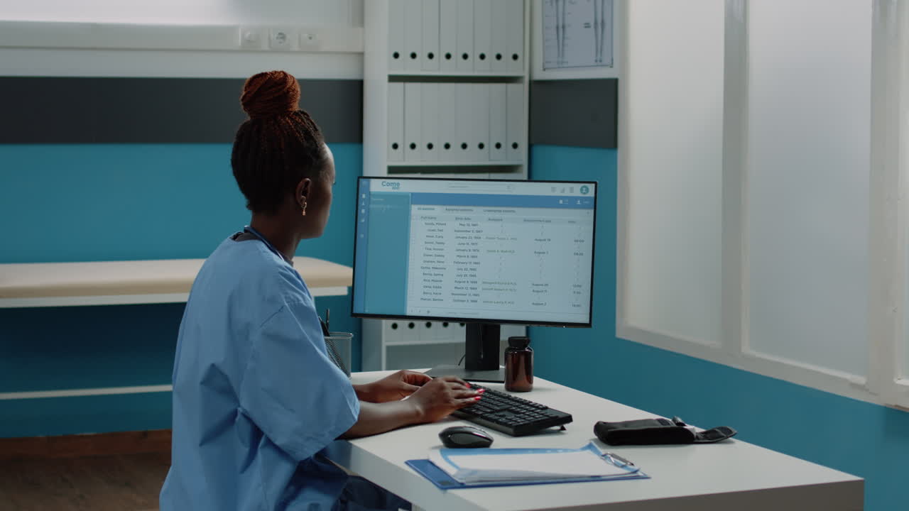 Medical professional working with patient records on computer in a medical office