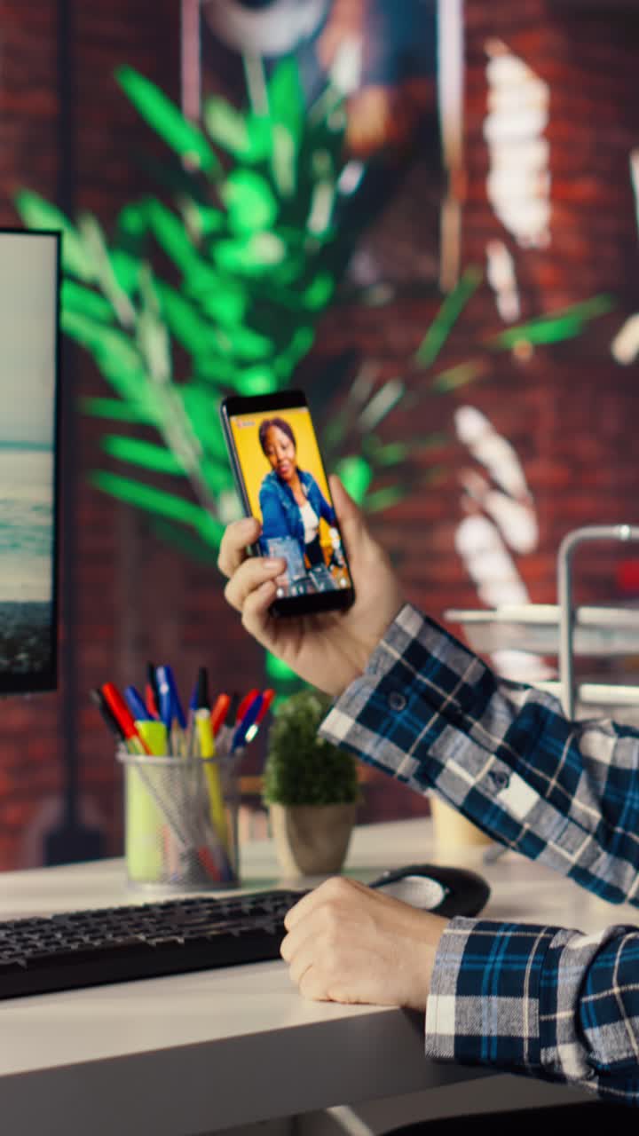 Vertical video Man in home office looking at social media feed with live broadcasts