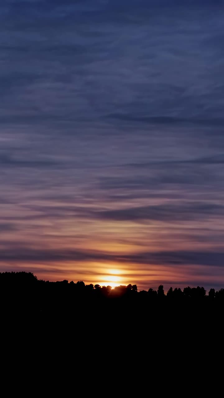 A serene sunset video captures the horizon at eye level, with soft purple and orange hues blending
