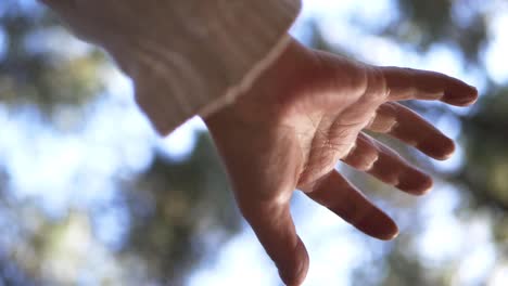 single hand reaching out against bokeh lights background medium shot