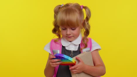 chica alumna divertida jugando con pop es sensorial anti-estrés juguete niño presiona en coloridas burbujas blandas