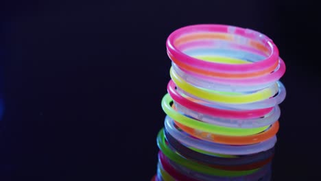 animation of multiple colorful neon glow sticks and light spots over black background