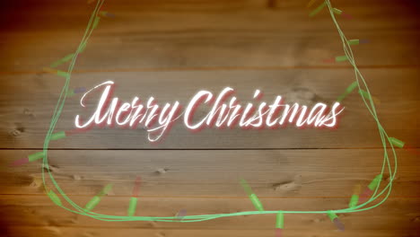 animación de texto de feliz navidad y luces de hadas en fondo de madera