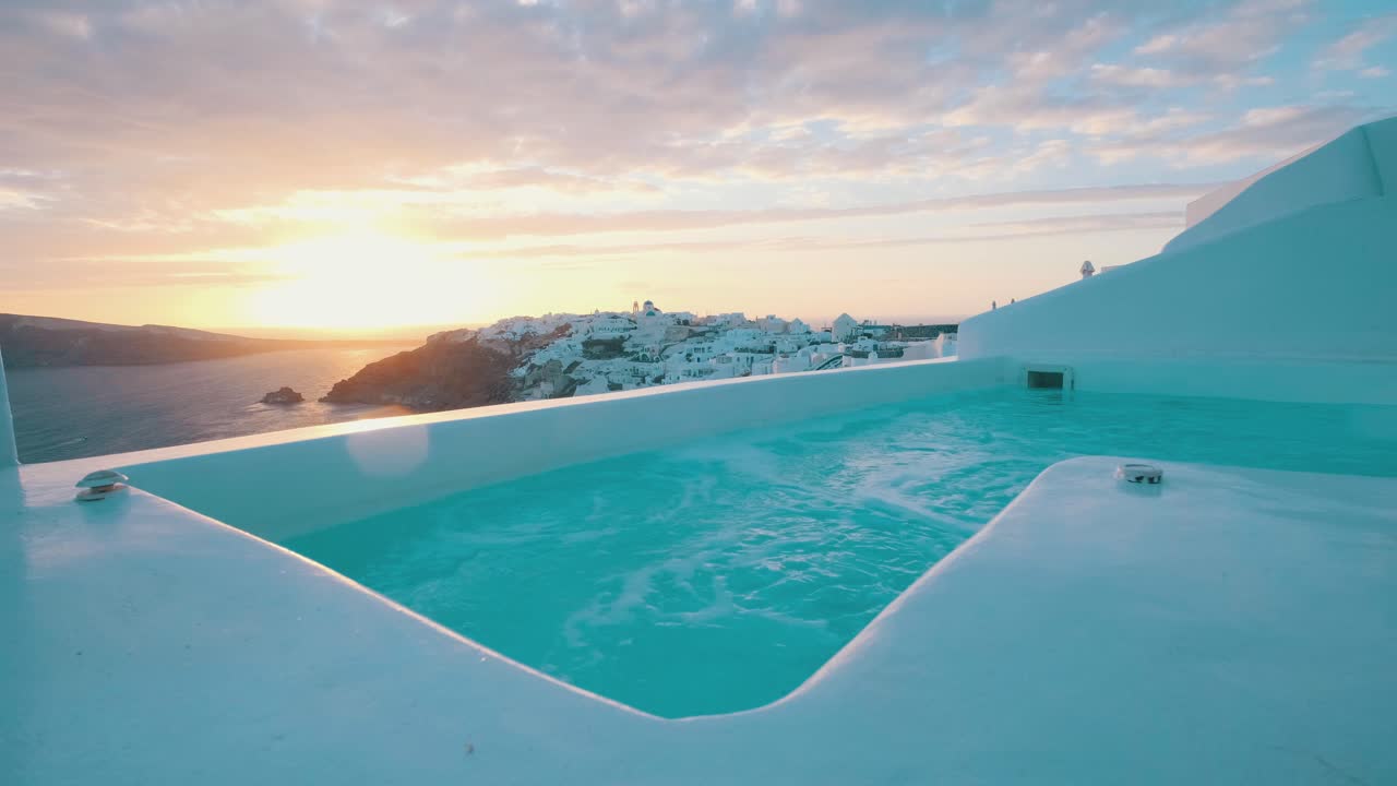 gran piscina con jacuzzi burbujeante frente al pueblo de oia, santorini