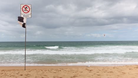 Erleben-Sie-Die-Kraft-Der-Natur,-Denn-Eine-Strandflagge-Warnt-Vor-Surfbooten-Bei-Windigen-Und-Bewölkten-Bedingungen