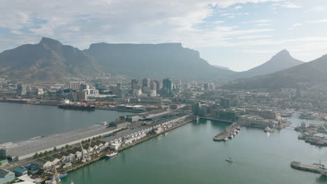 Los-Delanteros-Vuelan-Sobre-El-Paseo-Marítimo-De-Victoria-Y-Alfred-Y-El-Puerto-De-Table-Bay.-Paisaje-Urbano-Y-Macizo-Montañoso-De-Mesa-Con-Superficie-Plana.-Ciudad-Del-Cabo,-Sudáfrica