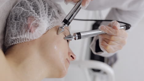 Kosmetikerin-Arzt-Lässt-Frau-Mikroströme-Gesichtstherapie-Mit-Elektrischen-Impulsen-Im-Spa-Salon