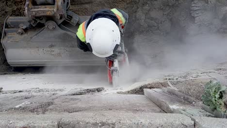 slow motion of a man cutting cement with a concrete saw