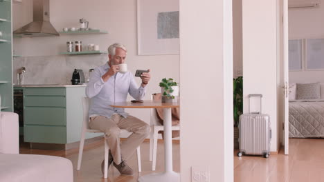 happy old man using smartphone texting browsing online reading social media messages enjoying relaxing retirement lifestyle at home