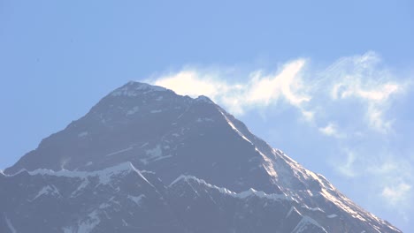 snow blowing off the top of mount everest on a clear blue morning