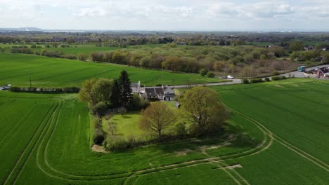 rural cheshire farmhouse aerial view surrounded by lush green trees and agricultural farmland countryside fields