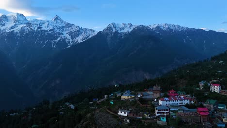 una fotografía aérea de la belleza serena de kalpa con el pico sagrado kinner kailash en la distancia.