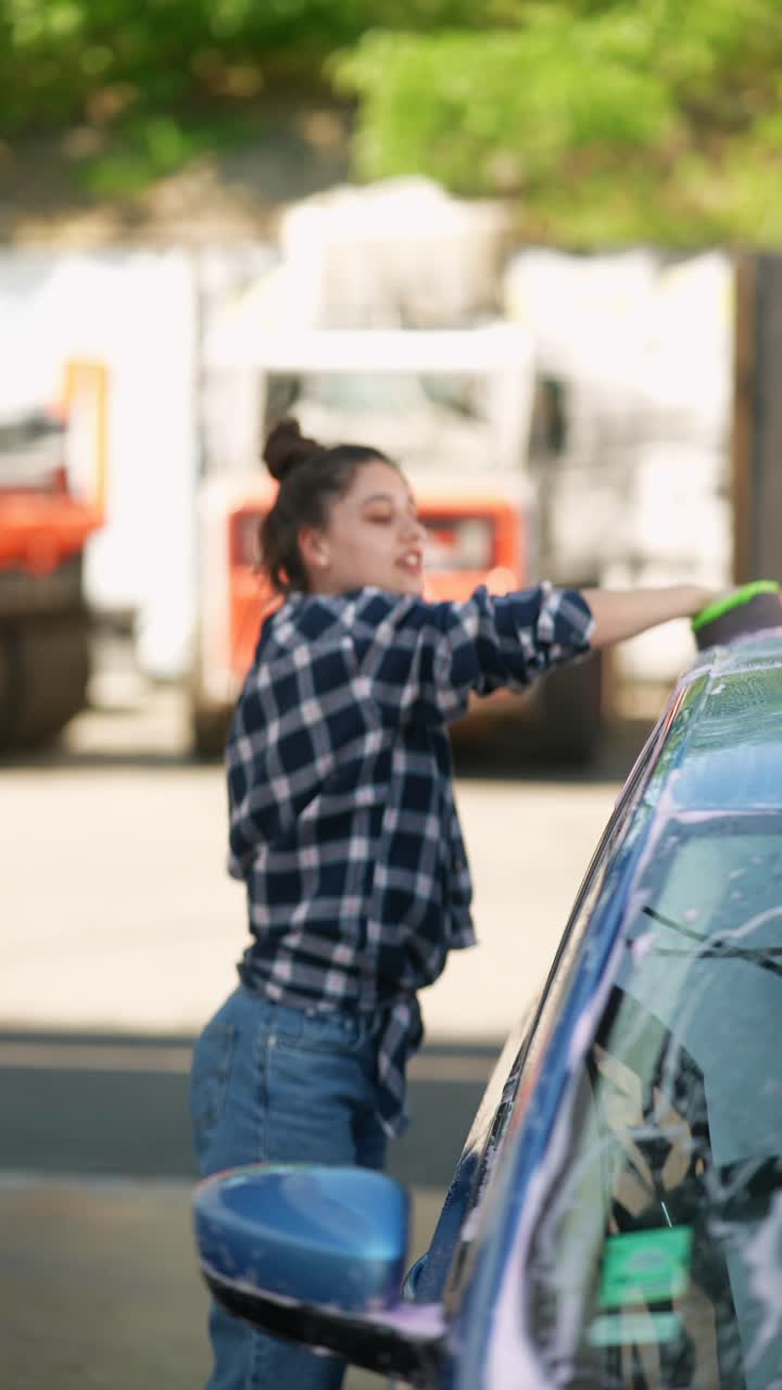 una mujer lavando un coche.
