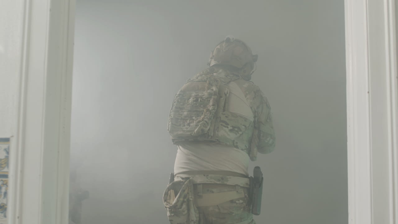 soldados abriendo la puerta con el pie y entrando en una habitación