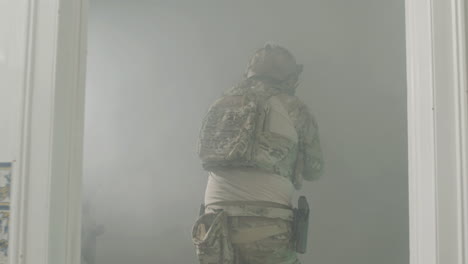 soldiers opening door with foot and entering into a room