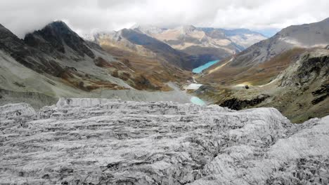 sobrevuelo aéreo junto al borde del glaciar moiry cerca de grimenz en valais, suiza con grietas heladas, valle y lago en una tarde nublada de verano