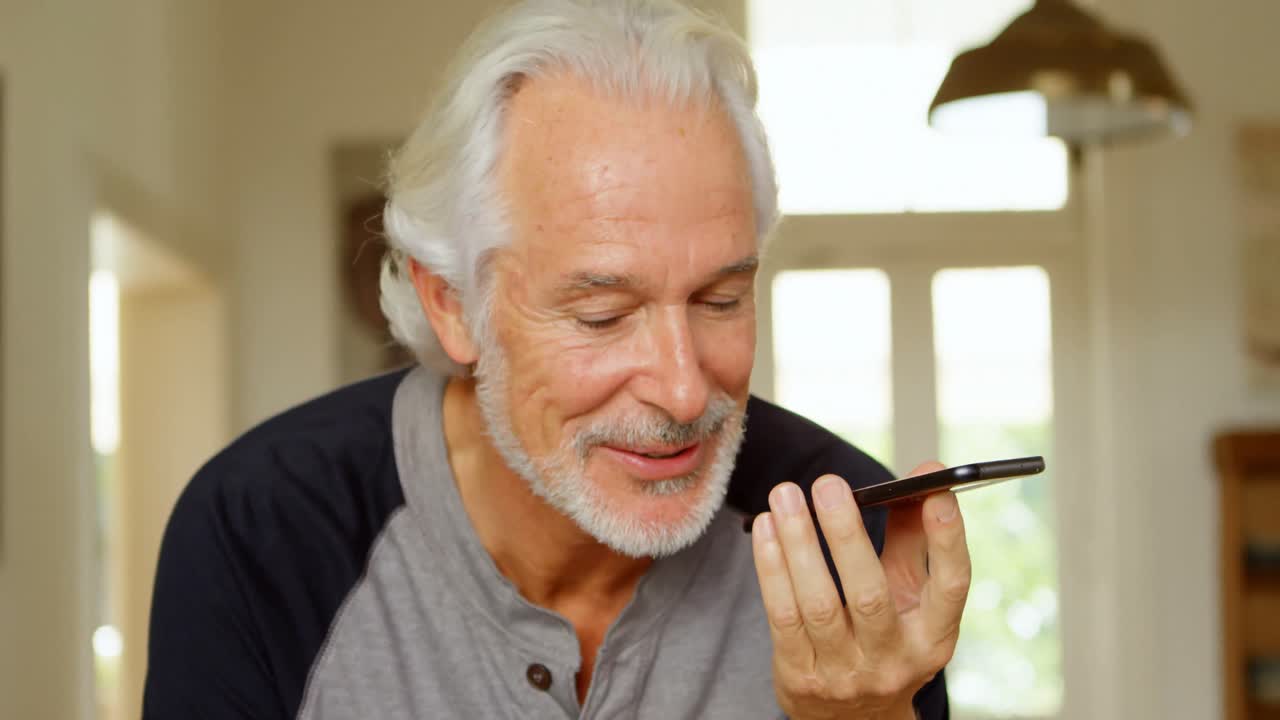 Senior man talking on mobile phone at home 4k