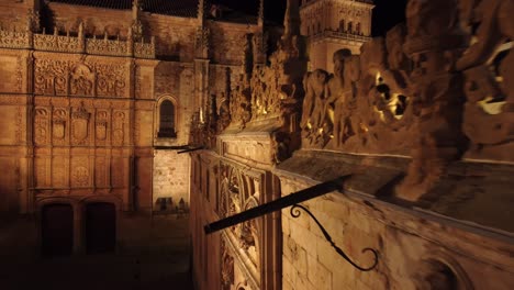 following the edge of the facade of a neoclassical heritage building in salamanca, spain, at close distance, illuminated at night