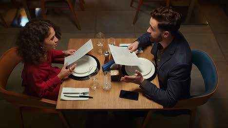 attractive couple choosing menu in night restaurant. romantic dinner concept.