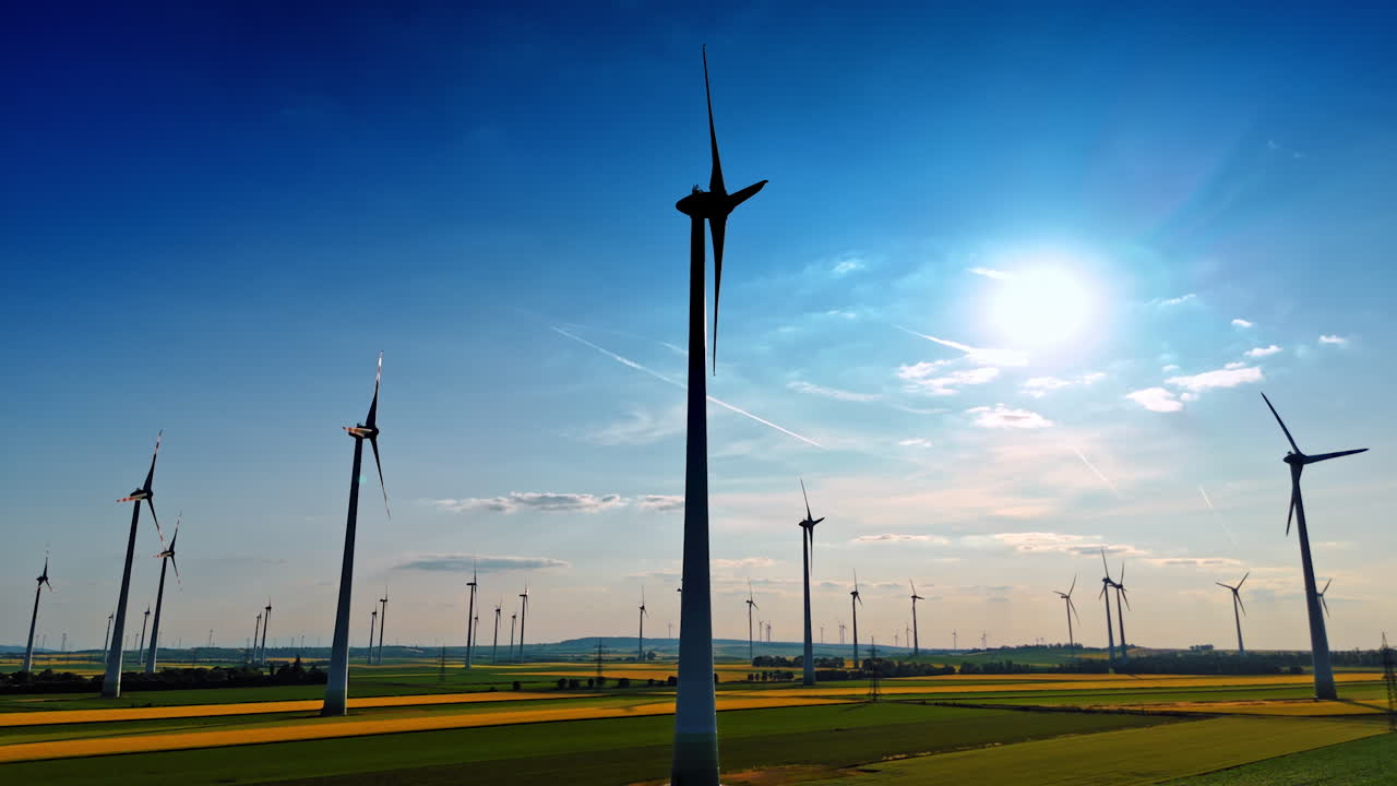 Sunset wind turbines generating. Rows of wind turbines stand tall in a scenic landscape as the sun sets, showcasing renewable energy in action