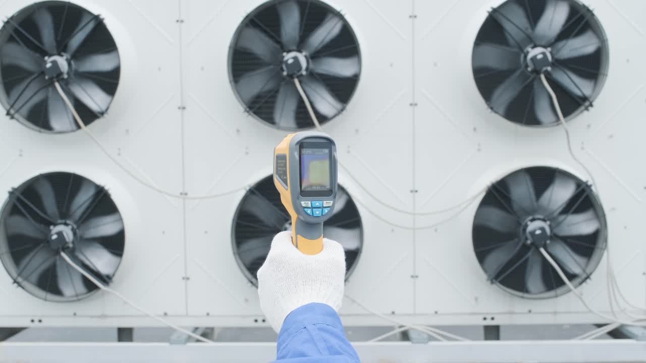 Technician uses a thermal imaging infrared thermometer to check the condensing unit heat exchanger