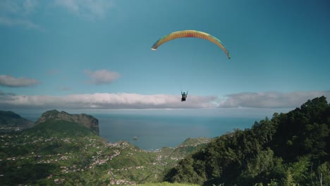 paraglider takes off from high mountain on madeira island, aerial