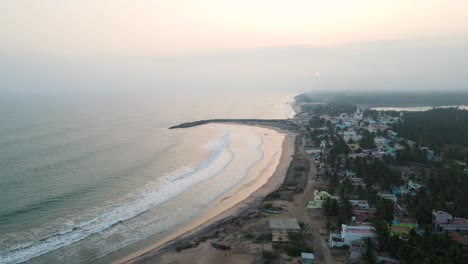 tomada aérea de un dron de kanyakumari, destacando el contraste del tranquilo océano y la vibrante ciudad durante la puesta de sol.