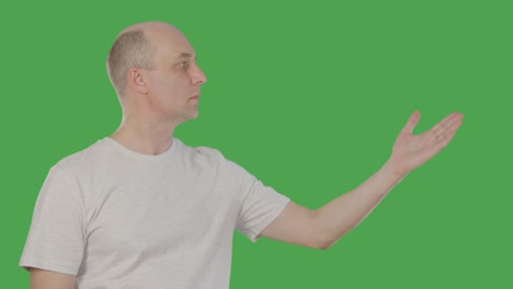 adult man pointing hand to side on something isolated on green background. alpha channel, keyed green screen