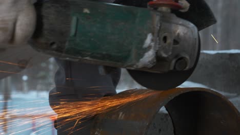 cutting metal pipe with angle grinder in winter