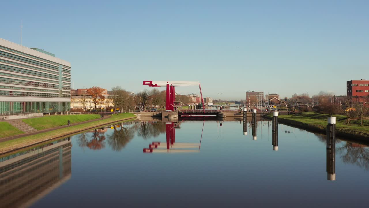 Low angle aerial shot flying away from a busy bridge in Middelburg above the canal