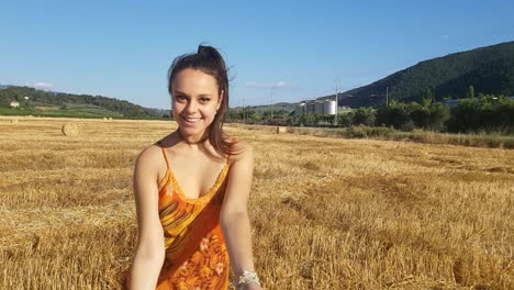 young brunette girl kissing towards camera in a wheat field at the beginning of summer while singing