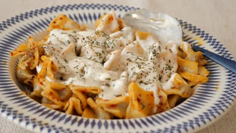traditional turkish manti with yogurt sauce and herbs