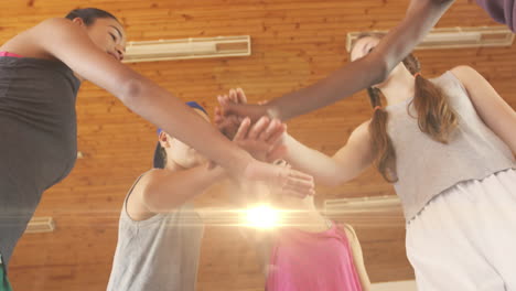 animation of light spots over diverse schoolchildren teaming up at gym