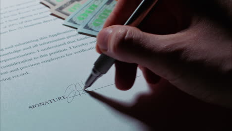 close up low angle shot of a female caucasian hand signing a document, with american money