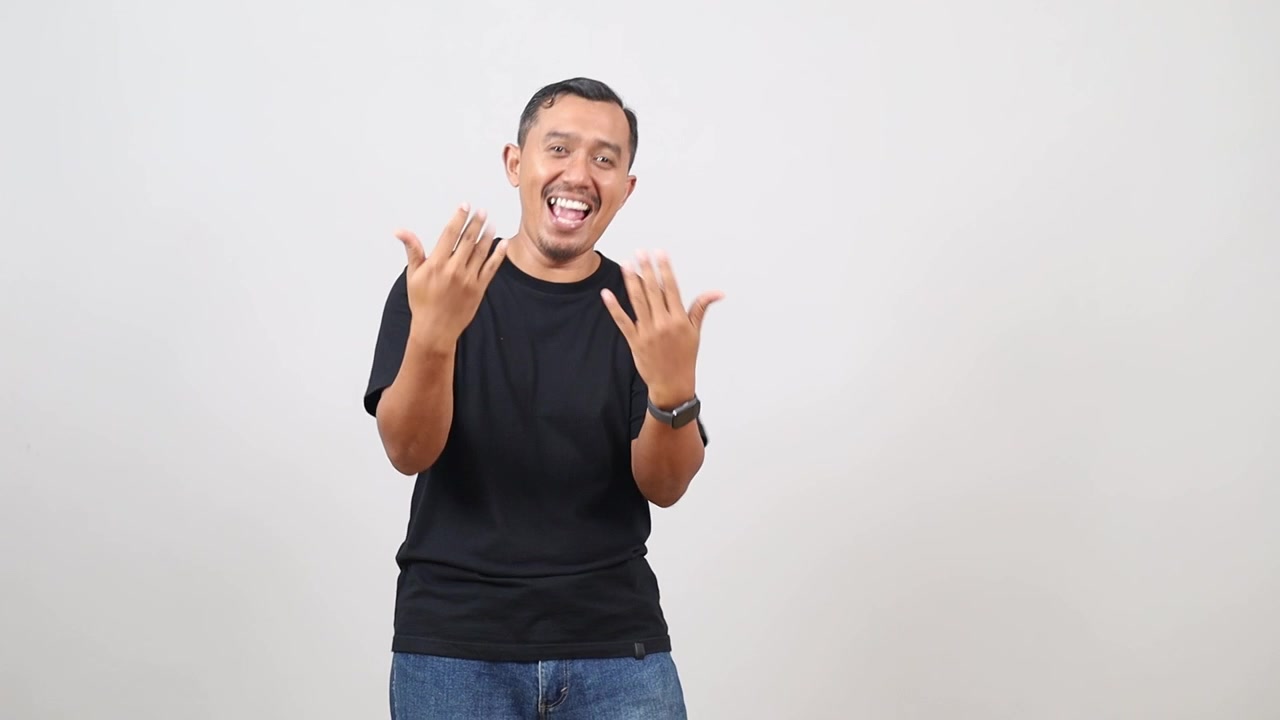 Ritratto di un uomo asiatico che invita ad avvicinarsi, sicuro di sé e sorridente, facendo un gesto con la mano, mostrandosi positivo e amichevole