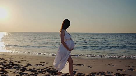 pregnant woman on beach at sunset